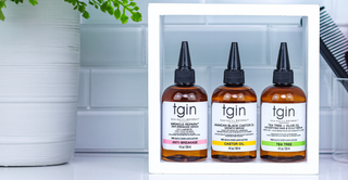 Three tgin serums on a white bathroom shelf