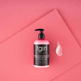 tgin Rose Water Frizz Free Hydrating Conditioner with a swatch on a pink background