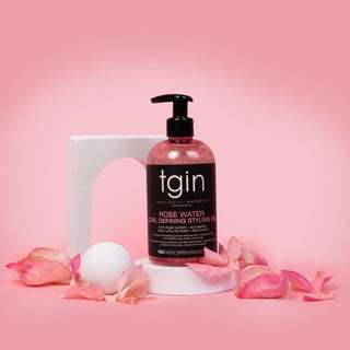 tgin Rose Water Curl Defining Styling Gel on a white stand with rose petals on a pink background