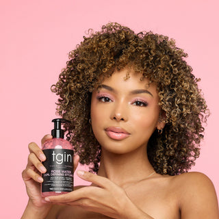 Woman with curly hair holding tgin Rose Water Curl Defining Styling Gel