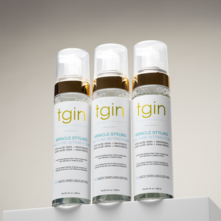 Three tgin Miracle Styling Multi-Use Setting Foam bottles on a white display block