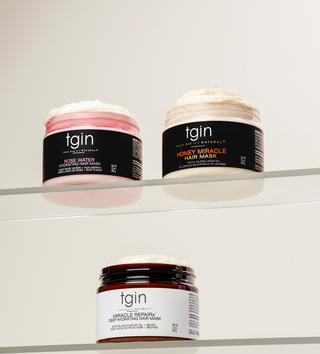 tgin Rose Water, Honey Miracle and Miracle RepaiRx hair mask jars on clear shelves, mobile