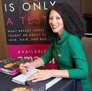 Chris-Tia Donaldson signing copies of her book This Is Only a Test