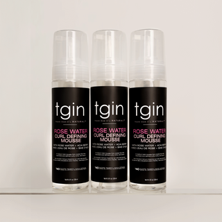 Three bottles of tgin Rose Water Curl Defining Mousse lined up on a shelf