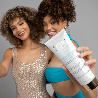 Two smiling women with curly hair, one holding out a tgin Miracle Styling Water-Activated Curl Elongating Gel tube