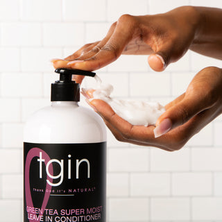 Hands pumping tgin Green Tea Super Moist Leave In Conditioner into a palm
