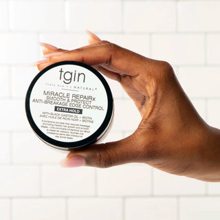 Hand holding a jar of tgin Miracle RepaiRx Smooth & Protect Anti-Breakage Edge Control, Extra Hold