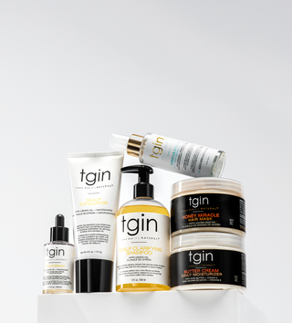 Assortment of tgin hair products on a white pedestal, mobile