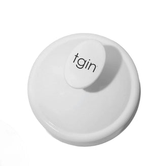 White tgin Scalp Massager seen from above, showing the tgin logo on the handle