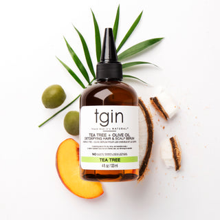 tgin Tea Tree & Olive Oil Detoxifying Hair & Scalp Serum with olives, coconut, peach slice, and leaves